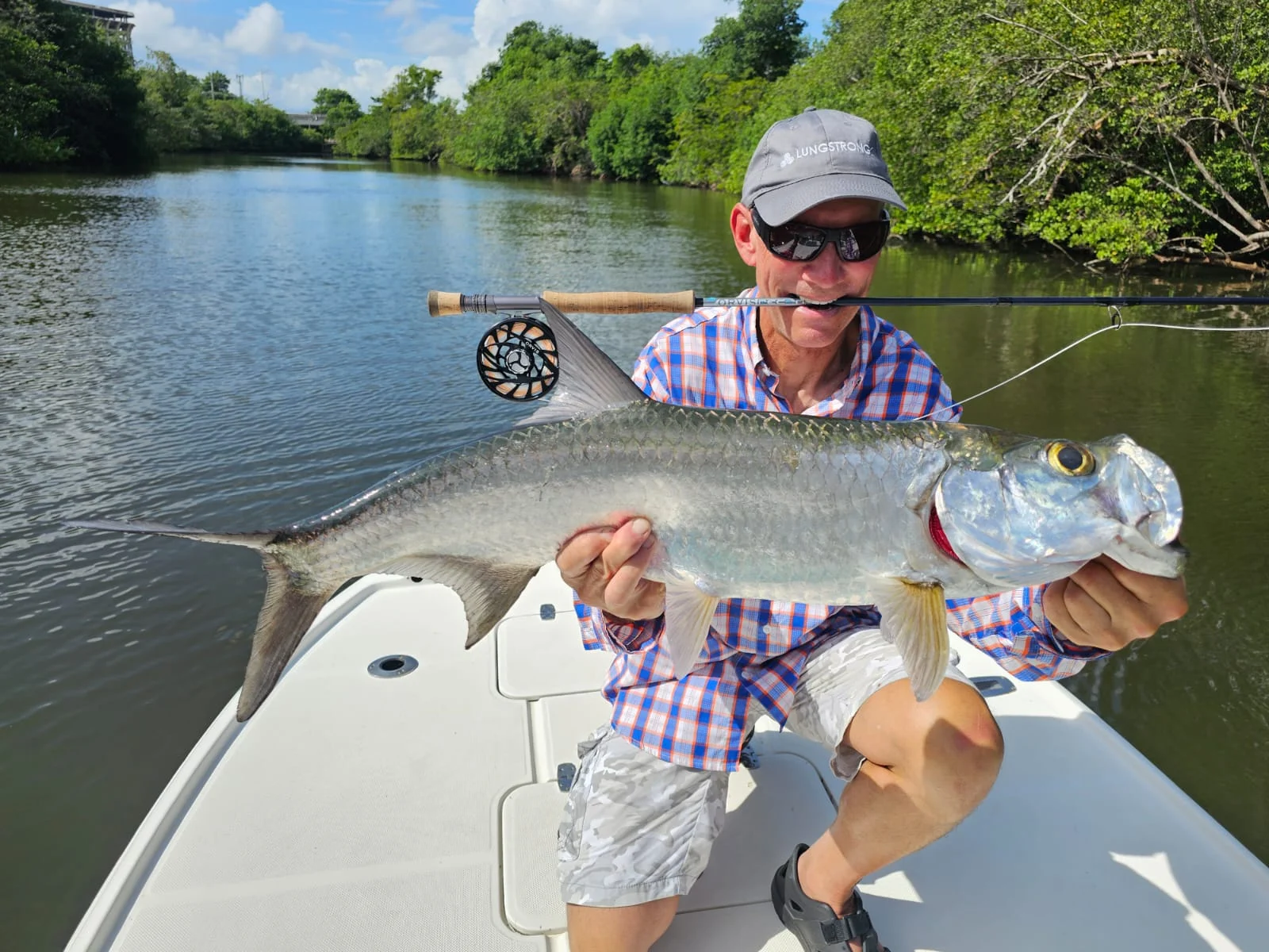 Angler with a tarpon and fly rod on the casting deck